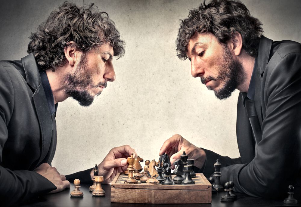 A man playing chess against himself to represent the game the universe is playing with itself