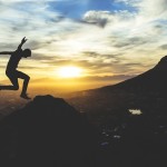 A man jumping over mountains to signify overcoming obstacles to success