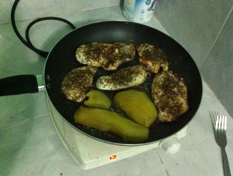 Chicken and sweet potato cooking in a frying pan