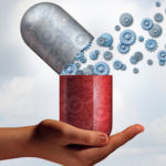 A hand holding a giant pill with gears coming out of it to signify cognitive enhancement through modafinil