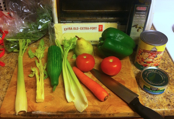 Salad ingredients cucumber, celery, carrots, tomatoes, pear, green pepper, tuna, mixed beans, cheese, kale, olive oil