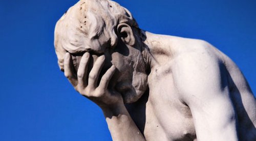 A stone statue with his head in his hand