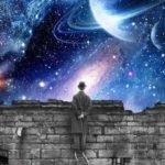Black and white man looking out over brick wall at the cosmos